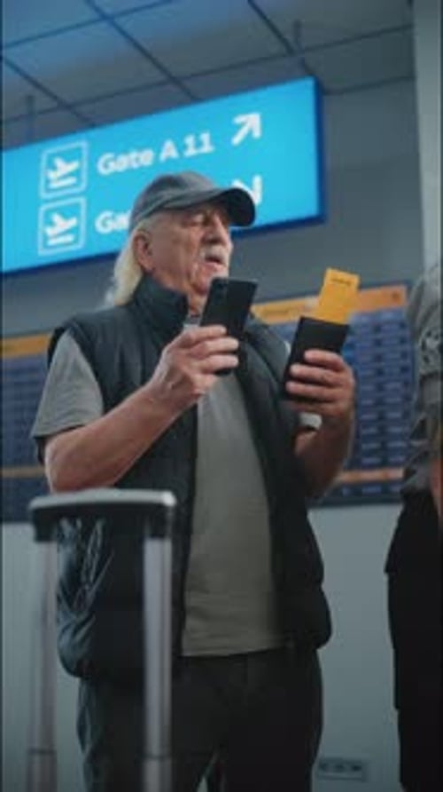 Airport Terminal Senior Man Scanning Plane Ticket Using Smartphone to Check Flight Information