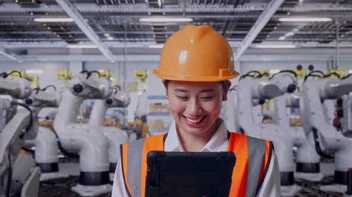 Close Up Of Asian Female Engineer Working On A Tablet With Robotic Arms