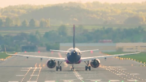 Passagierflugzeug hebt im Morgengrauen von einer stark befahrenen Landebahn in den Himmel