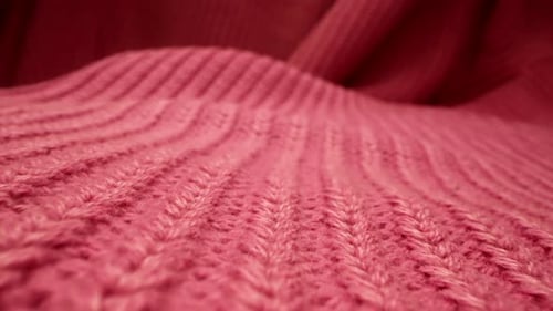 Macro Shot of Red Knitted Sweater Lying on Floor or Sofa Moving Closeup View of Woolen Pullover