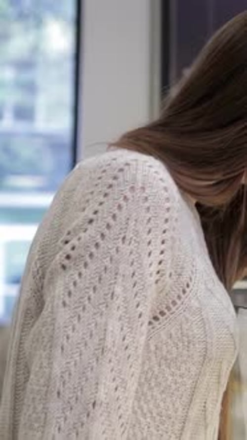 Young Woman Thoughtfully Selecting Delicious Pastries in a Cozy Coffee Shop