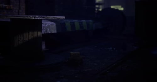 Urban Night Scene Featuring a Small Object in Low Light Near a Train Track