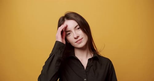 Smiling Woman Posing in Front of Yellow Background