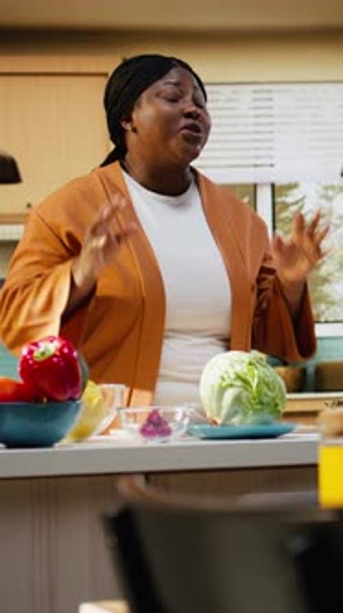 Una chef negra graba un vídeo tutorial de cocina en la encimera de la cocina