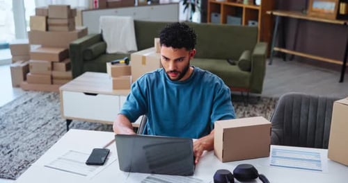 Young Adult Working on Laptop surrounded by Boxes