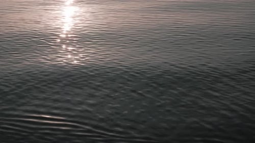Evening sun light reflected on sea, ocean water, calm waves