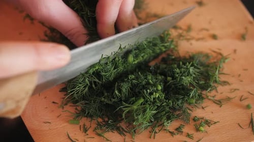 Cutting Dill Chef Cut Dill with Knife on a Wooden Board Close Up at Home