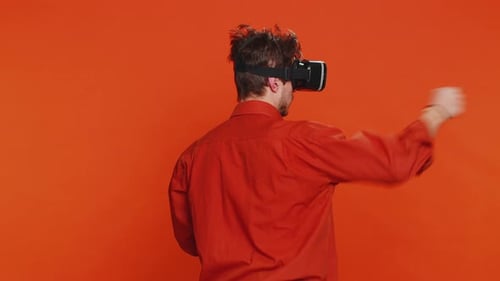 Hombre emocionado con casco de realidad virtual viendo vídeo 3D de realidad virtual jugando un juego de simulación en línea