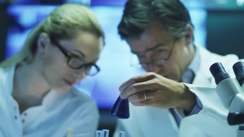 Scientists Researching Purple Liquid in a Laboratory