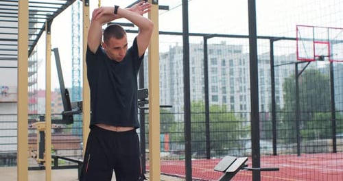 Man Stretching Arms at an Outdoor Gym