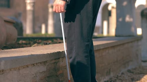young blind man walking in the street and going down stairs