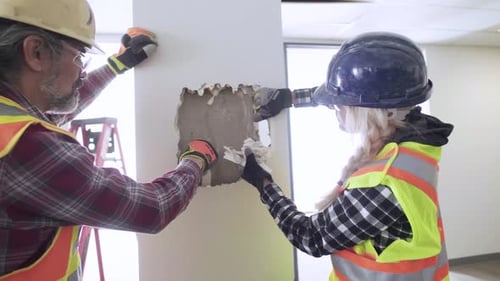 Construction team inspects pillar in vacant office space slow motion