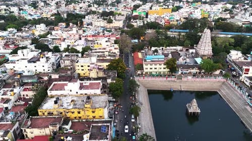 La vidéo montre un grand puits de temple et un gopuram élaboré. Une rue avec des voitures et des bâtiments