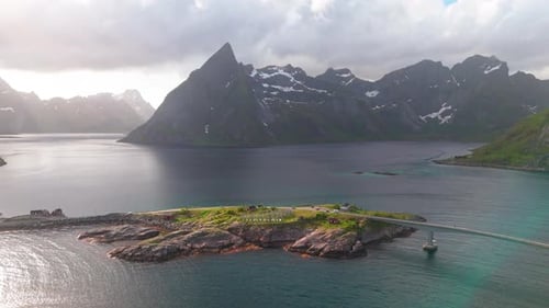 Descendo com a montanha Olstinden e as prateleiras de secagem de bacalhau da ilha Hamnoy em primeiro plano. Montanhas vastas