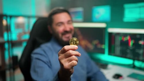 Man Holds Gold Bitcoin in Office Setting