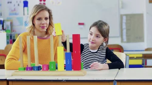 Jeune fille apprenant des fractions auprès d'un professeur en classe à l'école primaire