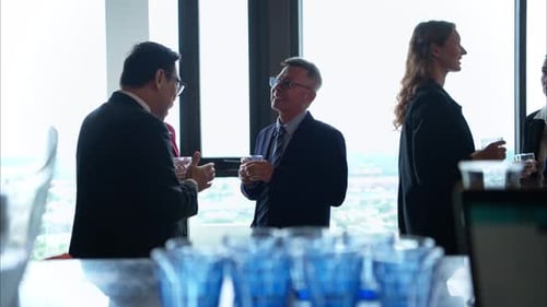 Business professionals networking and enjoying drinks at a corporate event in a modern office
