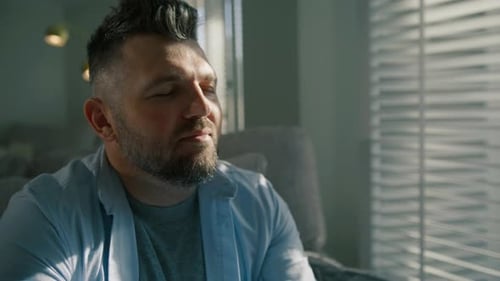 Man Looking out Window with Sunlight