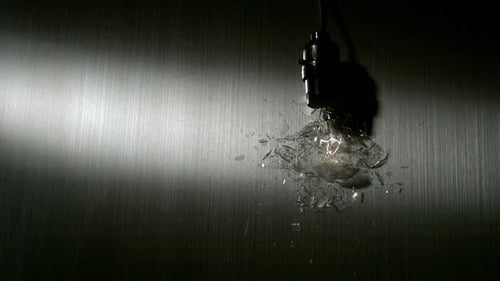 Light bulb breaking on metal surface in slow motion
