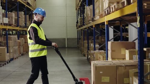 Warehouse worker loads pallet truck with packages for distribution