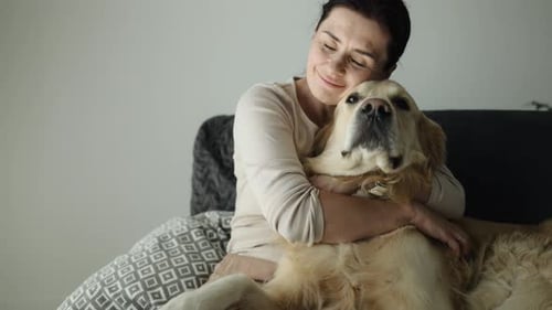 Woman Hugging Golden Retriever Pet Dog at Home