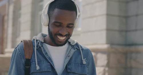 Young Adult Smiling While Using Mobile Phone Outdoors