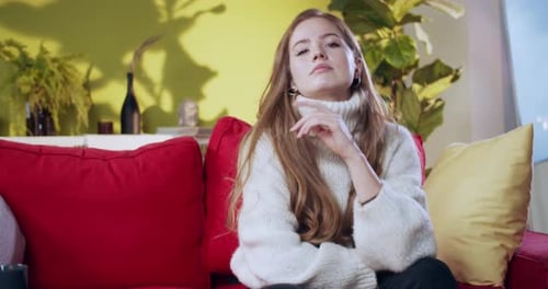 Unhappy Young Emotional Ginger Girl Sitting on Couch Taking Offense Showing Gloomy Sad Expression