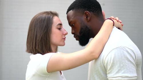 Um carinhoso casal multiétnico se beijando e se abraçando