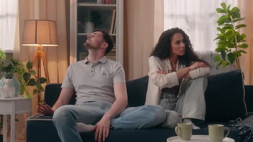 Upset Couple Sitting on Opposite Ends of Couch