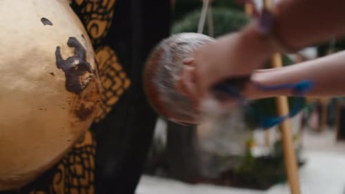 Persona golpeando un gong tradicional de un templo budista