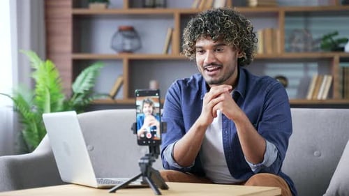 Confident young adult man private tutor giving video call lesson or training using mobile phone