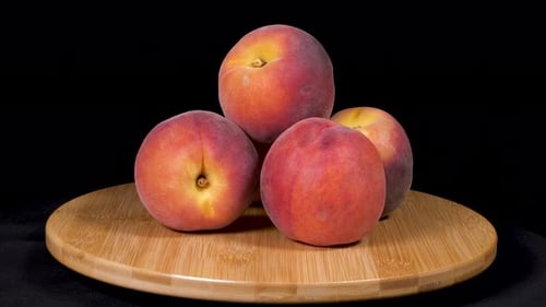 Fresh Peaches Stacked on Wooden Board