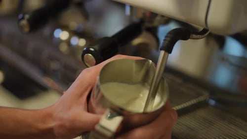 Closeup Warming Milk with Coffee Machine in Slow Motion in Coffee House High Angle View Closeup