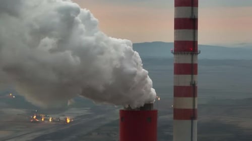 Smoke Billowing from Industrial Chimneys at Sunset