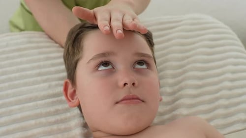 Child Receiving Gentle Head Massage Lying Down