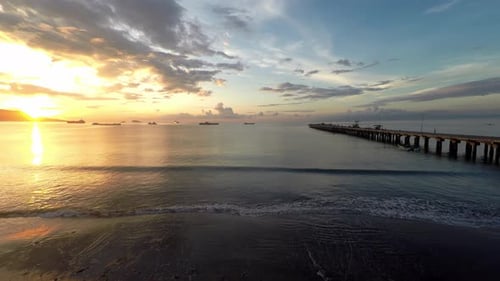 Drone aerial shot of a port, pier and fishermen haul nets from the ocean in the rays of sun