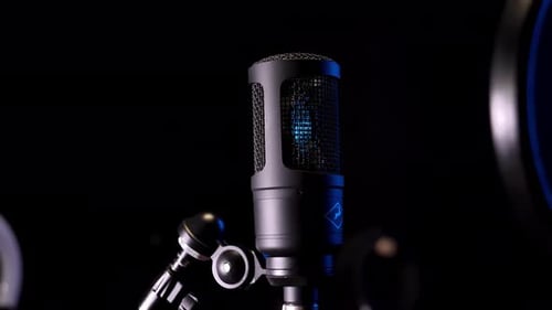 Studio condenser microphone, on background of neon pattern in blue.