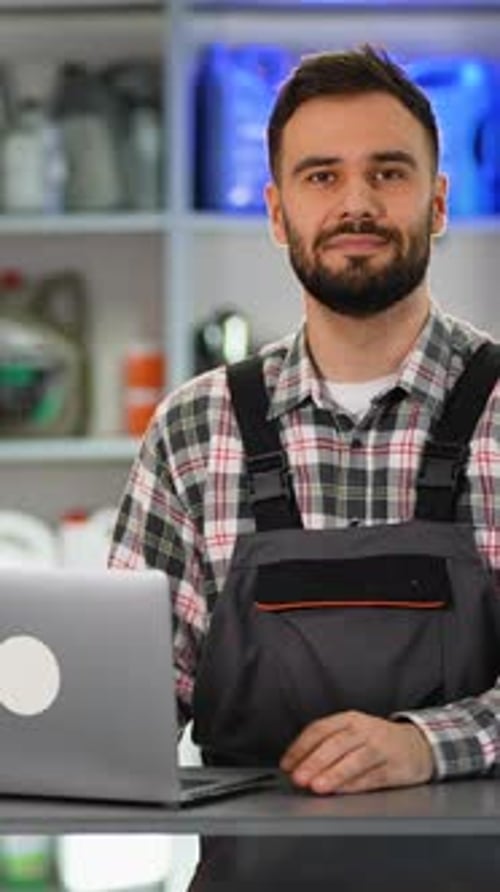 Man Works on Laptop in Automotive Repair Shop
