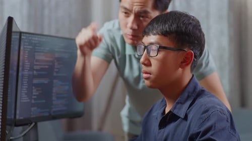 Pai asiático gritando com seu filho enquanto criava um engenheiro de software desenvolvendo aplicativo e programa