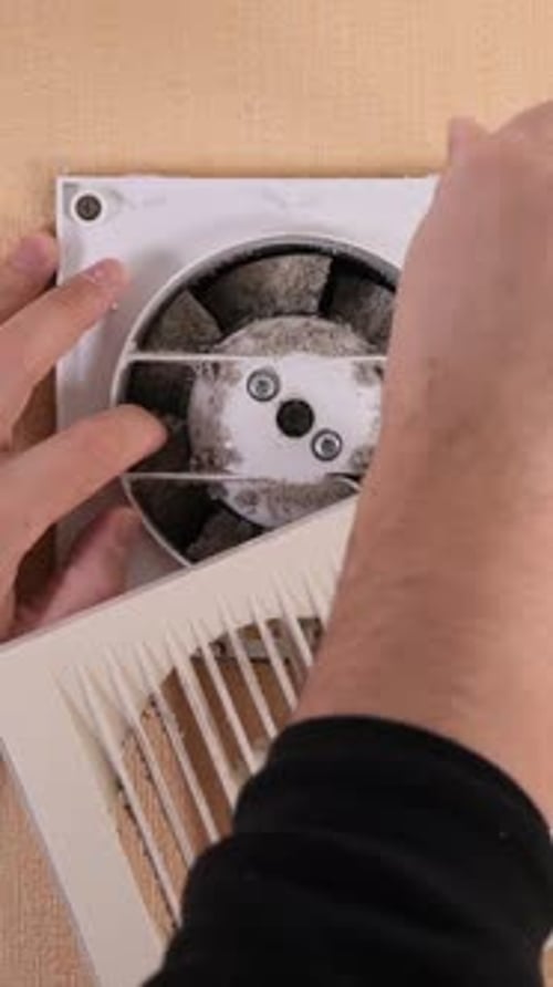 Vertical Video Technician Repairing Dusty Exhaust Fan in Bathroom