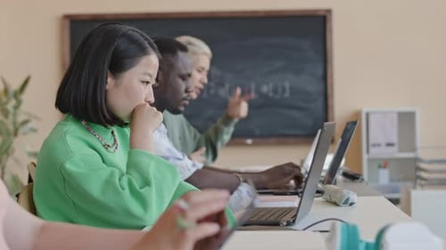 Asian Girl Using Laptop and Talking with Friend on Programming Class