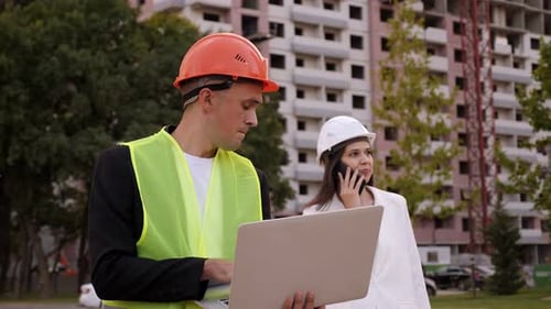 Dos ingenieros con chalecos y cascos discuten el proceso de construcción