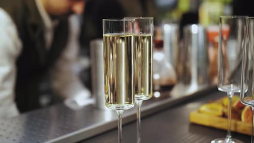 Pouring Sparkling Wine in Champagne in Two Glasses at the Bar Counter Slow Motion