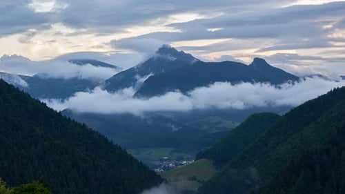 Misty Mountains Hidden in Foggy cloudsThere is a Small Settlement in the Valley Below the Mountains