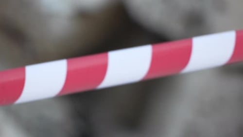 Fita de advertência vermelha e branca balançando no sinal de proteção contra o vento Não cruze a linha vermelha e branca