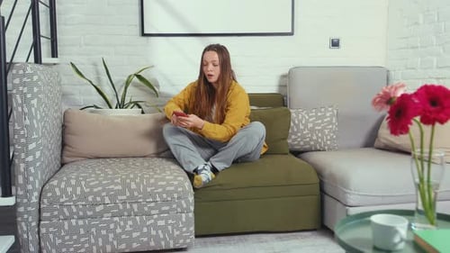 Woman Using Smartphone on Couch at Home