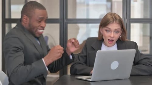 Colleagues Celebrate Good News Looking at Laptop in Office