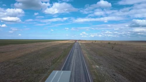 Highway In The Steppe With Passing Trucks