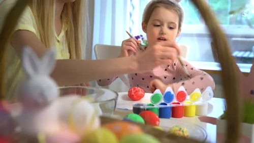 Mother and Daughter Painting Easter Eggs Together at Home