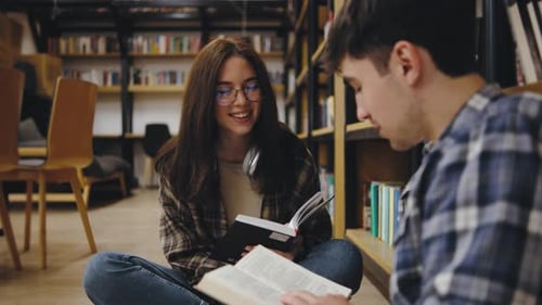 Young Adults Enjoy Reading Together in a Cozy Library Setting During a Calm Afternoon While